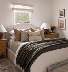 a bedroom with a bed, nightstands and two lamps on either side of the bed