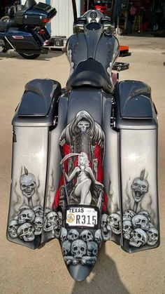 a custom painted motorcycle parked in a parking lot with skulls on the front and sides