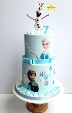 there is a three layer cake decorated with frozen princesses