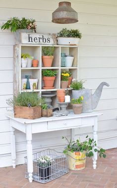 a white bench with potted plants on it and a sign that says herbs above the bench