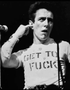 black and white photograph of a man holding a microphone in front of his face with words on it