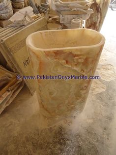 a large vase sitting on top of a table next to stacks of boxes and papers