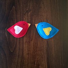 two felt birds sitting on top of a wooden table