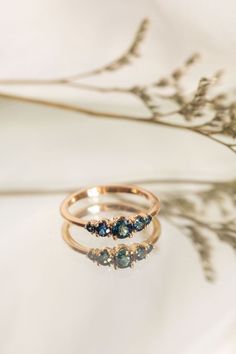 two rings sitting on top of each other with blue stones in the middle of them