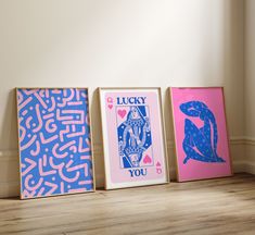 three framed art pieces sitting on top of a wooden floor