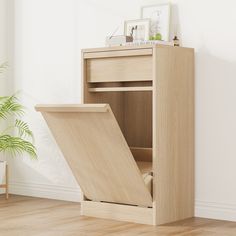 a wooden cabinet with an open door on the bottom and shelves above it, next to a potted plant