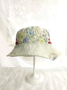 a white hat with embroidered flowers on it