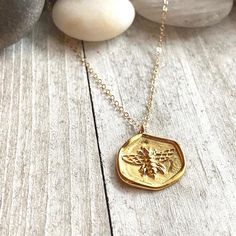 Bee Necklace, Gold Bee Necklace, Bee Pendant Necklace,Bee Coin Necklace,Bee Necklace Gold,Gold Bee Necklace, Bee Jewelry,Honey Bee Necklace A darling little necklace featuring a charming little gold honey bee.  The perfect gift for someone you love and full of special meaning. The bee, as a totem animal, are for those whose greatest wish is for all living things to co-exist in peace and harmony. In Egypt, the bee was a symbol of royalty and power. This comes from the legend that the bee was born Delicate Handmade Gold Charm Necklaces, Tiny Gold Necklace For Her, Handmade Gold Charm Necklace For Mom, Handmade Honey Color Jewelry Gift, Handmade Honey Jewelry For Gift, Handmade Honey-colored Jewelry For Gifts, Gold Dainty Charm Necklace For Mom, Dainty Gold Charm Necklace For Mom, Turquoise Earrings Gold