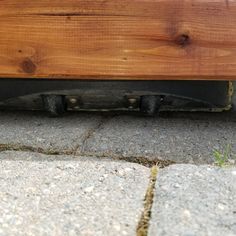 the bottom part of a wooden bench on concrete