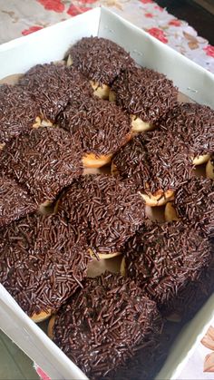 a box filled with chocolate covered donuts on top of a table