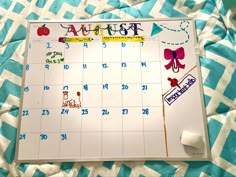 a calendar with stickers on it sitting on top of a quilted bed sheet