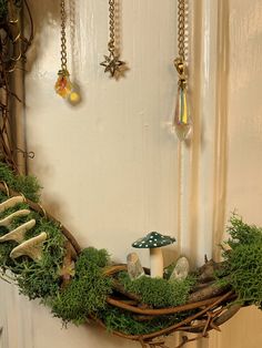 a wreath with moss and mushrooms hanging from it