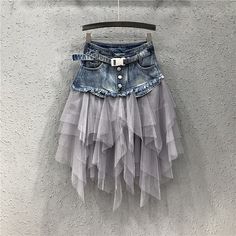 a skirt hanging up against a wall with a belt on the waist and two layers of tulle attached to it