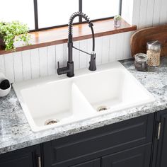 a kitchen sink with two faucets in it