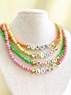 "Welcome to our vibrant and joyful personalized name necklace collection! Our colorful necklaces are perfect for children and make for a wonderful kids' birthday gift, designed to bring smiles to their faces. With six stunning color options to choose from, each necklace is a unique masterpiece. Crafted with colorful beads and adorned with Mother of Pearl letters that spell out a custom name, these necklaces are truly one of a kind. Make your little one's day special by gifting them a personalized name necklace that reflects their unique personality and style. Whether it's for a birthday, a special occasion, or just to show your love, these necklaces are sure to be cherished keepsakes.\" HOW TO ORDER ? 1- Choose the letter quantity of the name/word/phrase/initials you want. 2- Find the righ Trendy Personalized Charm Necklaces For Birthday, Trendy Personalized Charm Necklace For Birthday, Trendy Customizable Charm Necklaces For Gifts, Trendy Customizable Charm Necklaces As Gift, Trendy Personalized Necklace For Birthday, Whimsical Personalized Necklace For Birthday Gift, Fun Pink Personalized Charm Necklaces, Personalized Pink Fun Charm Necklaces, Personalized Pink Charm Necklaces