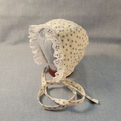 Made to Order. Crafted with love and care from 100% cotton and lace trim, this handmade cotton baby bonnet is a charming accessory for your little one. Made from soft, breathable cotton, it ensures comfort and style in one adorable package. The delicate craftsmanship of this bonnet adds a touch of artisanal flair to your baby's ensemble. Whether worn for a special occasion or as a daily accessory, this bonnet is both practical and delightful. Its timeless design and high-quality materials make it a thoughtful gift for new parents or a sweet addition to your baby's wardrobe. Add a touch of handmade beauty to your baby's look with this lovely cotton baby bonnet. Perfect for protecting your baby's delicate skin from the sun or wind, this bonnet is as functional as it is adorable. The adjustab Adjustable Cotton Bonnet With Lace Trim, Fitted Cotton Bonnet With Lace Trim, Fitted Cream Bonnet With Lace Trim, Adjustable Cotton Vintage Bonnet, White Cotton Bonnet As A Gift, White Cotton Bonnet As Gift, Cute Cream Cotton Hat, Fitted Cotton Cream Bonnet, Cute Handmade Cotton Hat