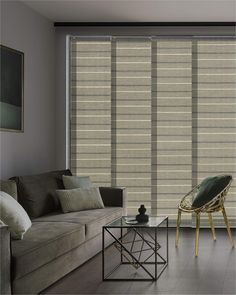 a living room with a couch, chair and window covered in vertical blind blinds that are beige