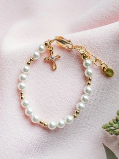 This keepsake bracelet is made with high-end Austrian simulated pearls and 14K Gold-plated beads accented with a dainty infinity cross charm embellished with sparkling CZs! This is a high quality bracelet designed with sterling silver with 14K gold plating. This makes a very special baptism gift, christening bracelet, dedication gift, or First Communion gift for girls. Each bracelet has an extension chain, as the child grows just move to the next link for a perfect fit. Made in the USA Baby Bracelet Gold, Communion Gifts Girl, Infinity Cross, First Communion Gifts, Baby Bracelet, Communion Gifts, Cross Charms, Gold Pearl, Bracelet Designs