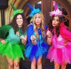 three women dressed in costumes standing next to each other