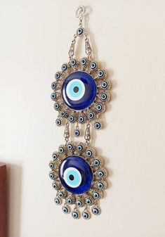 There are 2 Large Evil eye beads and 40 tiny evil eye beads on the silver hanging. Blue evil eye beads are 7 cm(2.7 in) Width of the zamak evil eye is 11.5 cm(4.5 in) Height of the metal evil eye hanging is 32 cm(12.5 in) You can place this Turkish ornament in your home or Office for protection. For more evil eye hangings, click the link below; https://www.etsy.com/shop/EyeDesignsbyGG?ref=search_shop_redirect&section_id=30211705 Handmade Blue Evil Eye Bracelet, Blue Evil Eye Bracelet For Festivals, Traditional Blue Evil Eye Jewelry, Bohemian Silver Evil Eye Bracelet, Dupatta Styling, Evil Eye Hanging, Evil Eye Decor, Jute Craft, Evil Eye Wall Hanging