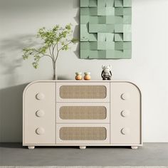 a white cabinet with two vases on top of it