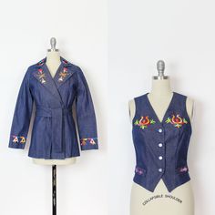 "Vintage 1970s embroidered denim jacket and vest set with flowers, geometric shapes, feathers and axes in a rainbow of colors. Jacket has a notched lapel, nipped waist a double button closure at the front (one at the inside waist and the other at the outer waist) and a matching denim tie belt. Vest is fitted with a nipped waist and full button down front. Made of a medium weight dark wash denim and both pieces are fully lined. Vest is more fitted than the jacket but the jacket does have smaller Retro Blue Vest For Spring, Fitted Cotton Folk Outerwear, Folk Style Fitted Cotton Outerwear, Fitted Folk-style Cotton Outerwear, Fitted Cotton Vest With Floral Embroidery, Fitted Floral Embroidered Vest For Fall, Retro Cotton Denim Vest For Spring, Retro Cotton Vest For Spring, Summer Cotton Denim Vest With Floral Embroidery