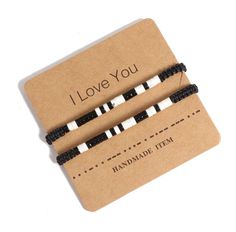 two black and white striped bracelets with i love you written on the front, one in