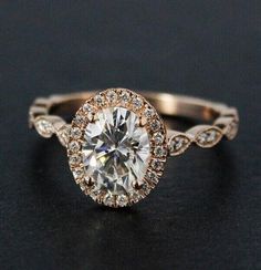 an engagement ring with a round cut diamond surrounded by small white and rose gold diamonds