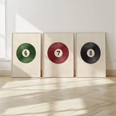 three canvases with numbers on them sitting in front of a white wall and floor