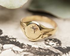 A shiny unisex signet ring! The antique ring has an oval top and is high polished. It is decorated with a set diamond on the surface and has an engraved star as the stones 'collet'. You can wear this ring with your everyday outfits, or for special occasions.  Hallmarks: The ring is stamped 9ct. Condition: Is in fair antique condition with some scratches as you will notice from the pictures. A great graduation ring, a best friends present, or a treat to yourself and a timeless piece to your jewel Classic Oval Signet Ring With Rose Cut Diamonds, Oval Signet Ring With Single Diamond For Gifting, Oval Signet Ring With Single Diamond For Gift, Oval Signet Ring With Rose Cut Diamonds For Anniversary, Oval Engraved Ring With Single Diamond For Gift, Oval Engraved Ring With Single Diamond As Gift, Vintage Signet Ring With Single Diamond For Gift, Vintage Oval Diamond Ring With Polished Finish, Oval Signet Ring With Rose Cut Diamonds For Promise