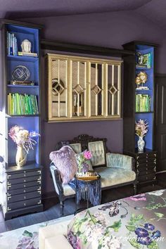 a living room with purple walls and furniture