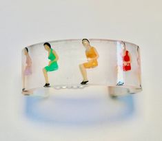 Sitting ladies encased in a resin cuff bangle. Has a safety chain as shown. One size fits all. Arrives gift wrapped. Resin Bracelets As Gifts, Lucite Bangle Bracelet As Gift, Lucite Bangle Bracelets As Gift, Lucite Bangle Bracelet For Gift, The Bangles, Safety Chain, Cuff Bangles, One Size Fits All, Cuff Bracelets