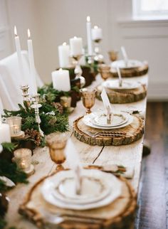 the table is set with candles, plates and place settings for an elegant christmas dinner