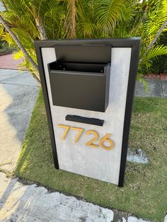 a mailbox with the number 726 on it in front of some palm trees