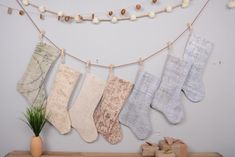 there are many socks hanging on the clothes line next to a potted green plant