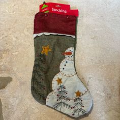 a christmas stocking with a snowman design hanging from the side on a wall