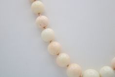 This is an incredible necklace made of Angel skin coral shell. Mostly white in color with some minor coral/pinkish tones. The beads are graduated with the center being the largest at approx 12 mm (see photo). Condition; Good vintage condition, no chips or visible damage. Clasp has a heavy patina due to age. Size; The largest bead is about 12mm, the next size down is about 10mm and the length of the necklace is approximately 22 inches long. Hallmarks; Clasp is sterling silver (tested) but there i Elegant Hand-strung Coral Necklaces, Elegant Coral Hand-strung Necklaces, Elegant Hand-strung Coral Necklace, Elegant Single Strand Coral Beads, Elegant Cream Necklaces With Large Beads, Elegant Coral Beaded Necklaces With Large Beads, Elegant Peach Necklaces With Round Beads, Elegant Peach Round Beads Necklaces, Elegant Coral Necklaces With Large Beads