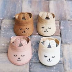 three pairs of baby shoes with bunny ears on the front and back, sitting on a tile floor