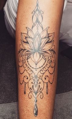 a woman's leg with a tattoo design on the lower half of her leg