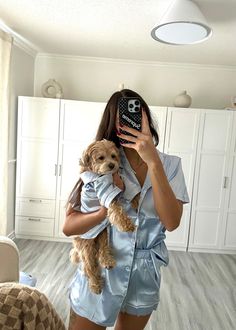 a woman taking a selfie while holding a dog