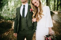 a man in a suit and tie standing next to a woman wearing a white dress