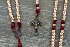 Crafted from high-quality materials, our "Strength and Virtue" rosary is built to last and withstand the challenges of daily life. This truly unique rosary boasts exquisite 10mm metal alloy Hail Mary beads in a stunning rose gold finish, elegantly complemented by antique copper Our Father beads. These durable and unbreakable components are paired with matching maroon paracord 275 for added strength and durability. This combination creates an aesthetically pleasing rosary that exudes both beauty Traditional Adjustable Hand-strung Rosary Bracelet, Bohemian Hand-strung Rosary For Healing, Green 8mm Beads Spiritual Rosary, Paracord Rosary, Traditional Hand-strung Rosary With Round Beads, Military Rosary, Hail Mary, Catholic Gifts, Gold Finish