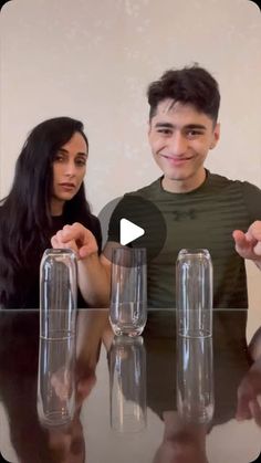 two people sitting at a table with empty wine glasses