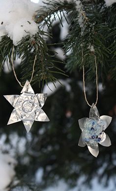 two ornaments hanging from a tree in the snow