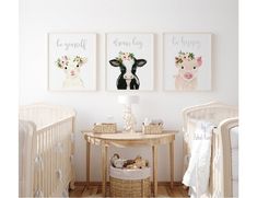 two baby cribs with pictures on the wall and a table in front of them