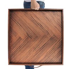 a person holding up a wooden framed object