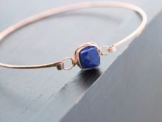 A simple, hammered 14K rose gold filled bangle features a gorgeous Lapis Lazuli faceted cube secured wtih 14k rose gold filled wire in my original bezel wrapped style for a modern and simple stacking bracelet. This bangle has a hinge style clasp to make it easy to put on take off and allows for a better fit. Bracelet - Choose your perfect fit. 7-7.5 inches in circumference is the most average size Lapis Lazuli Cube - approx 8 mm ** Photo #6 shows the same bracelets in Aquamarine & Pyrite wit Stacked Bangles, Rose Gold Bracelet, Jewellery Making, Bracelet Stack, Lapis Lazuli, Minimalist Fashion, Semiprecious Stones, Precious Stones, Gemstone Jewelry