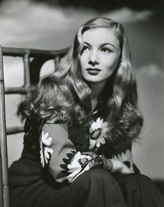 an old photo of a woman sitting in a chair