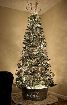 a decorated christmas tree in a pot with lights and ornaments on the top is lit up