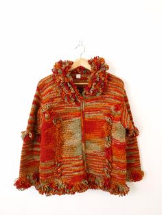 Vintage Red/Orange Stripe Zip up Fringed Chunky Sweater. Measurements Length:23"  Armpit to armpit: 20" Shoulder: 18" Shoulder to end of sleeve: 19" Condition: Gently used. There's no stains or holes. Good condition.  ※Please read the policy before you purchase※ Bohemian Orange Winter Outerwear, Orange Bohemian Outerwear For Fall, Orange Bohemian Fall Outerwear, Red Bohemian Sweater For Winter, Red Bohemian Winter Sweater, Bohemian Red Winter Sweater, Vintage Orange Sweater For Fall, Art Yarn, Chunky Sweater